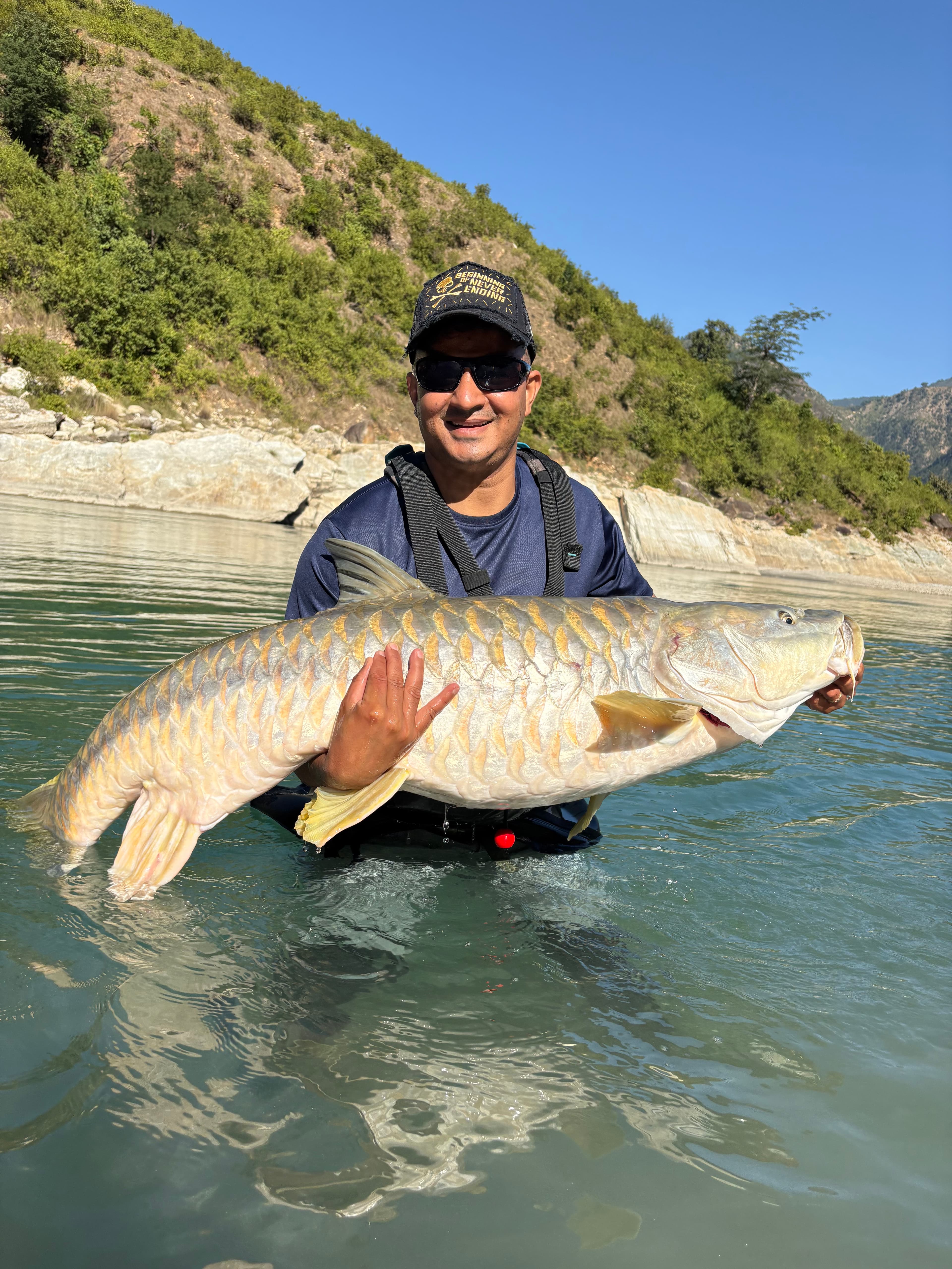 Guest holding a big fish by the river